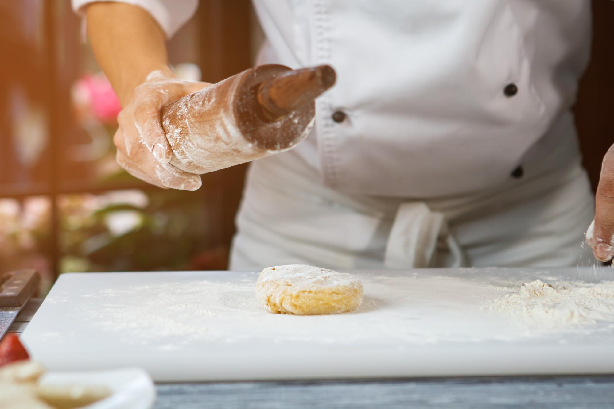 Hands preparing dough in kitchen